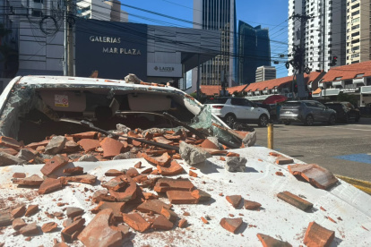 Un vehículo afectado por restos de un edificio tras un terremoto de magnitud 7,7 con una profundidad de 10 kilómetros en Panamá.