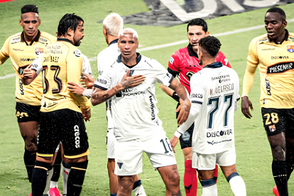 Deyverson (c.) durante el partido entre Liga de Quito y Barcelona.