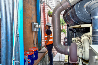Un trabajador revisa los medidores de energía eléctrica en una empresa, en Guayaquil.