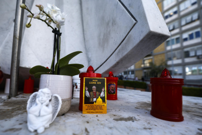 Una fotografía del papa León XIV colocada bajo la estatua de Juan Pablo II frente al Hospital Universitario Agostino Gemelli, donde el pontífice se encuentra hospitalizado, en Roma.