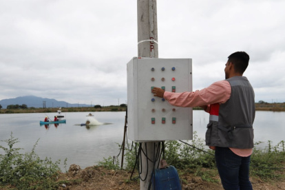 Una persona maneja la parte eléctrica en una camaronera de Ecuador.