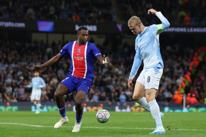 Willian Pacho (i), defensa del PSG, en la marca de Erling Haaland (d), delantero del Manchester City.