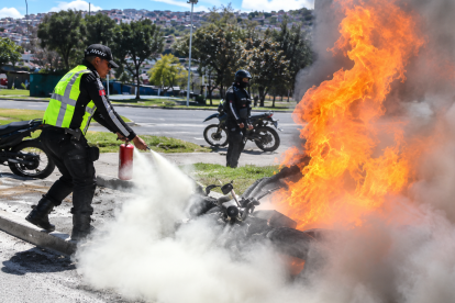 Una motocicleta se incendió durante un operativo de tránsito en Guajaló, al sur de Quito. Un agente de la AMT logró apagar las llamas.