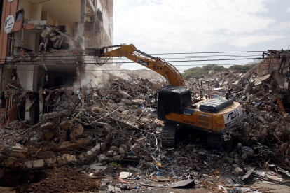 Fotografía que muestra una retroexcavadora durante el proceso de demolición de edificios afectados por el terremoto en Cali.