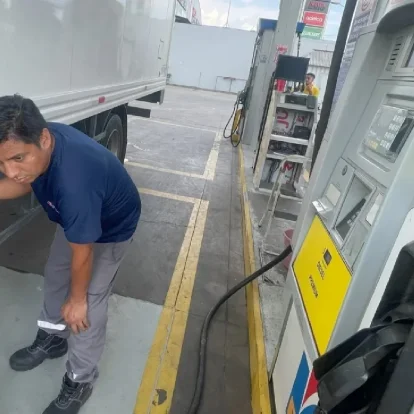 Trabajador carga diésel premium en camión en una gasolinera de Ecuador