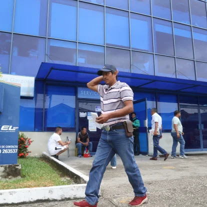 Una persona camina al pie de la empresa eléctrica en Guayaquil.