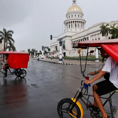 Un par de bicitaxis fue captado este 11 de julio frente al Capitolio de La Habana (Cuba), mientras el país padece el segundo apagón eléctrico nacional de esta semana y el cuarto del año.