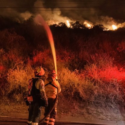 Bomberos de Quito intentan sofocar las llamas en el cerro Casitagua.