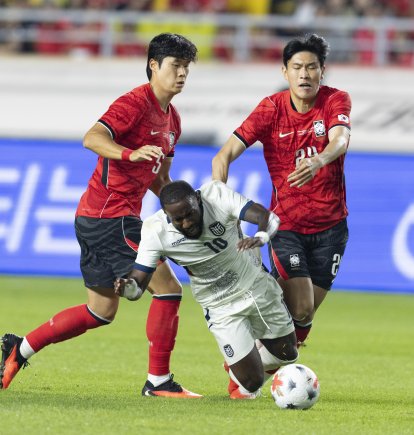 John Yeboah de Ecuador (C) cae ante la marca de Kim Bong-soo (d) y Kim Tae-hyeon de Corea del Sur el jueves pasado.