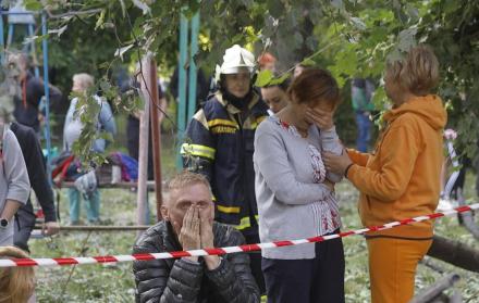 La gente local reacciona cerca del lugar de un ataque aéreo contra un edificio residencial de nueve pisos en Kiev, Ucrania.