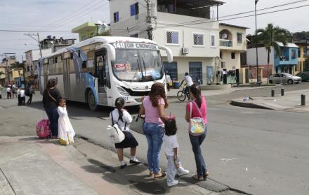 Espera. Varias madres de familia y sus hijos esperan que un bus pase para cruzar la vía 10 de Agosto.