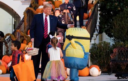 Trump coloca un chocolate en la cabeza de un niño, en lugar de en su funda de caramelos.