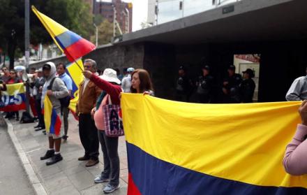 Varias personas acudieron a los exteriores del CNE con banderas del Ecuador.