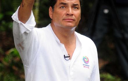 El expresidente Rafael Correa muestra su mano como señal del daño ambiental hecha por Chevron.