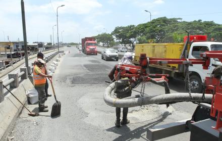 Flavio Alfaro. Personal del Municipio cumple con trabajos de bacheo en la rampa de bajada hacia la vía a Daule, lo que obligó el cierre parcial y con ello la lenta circulación vehicular. El deterioro de la carpeta asfáltica es permanente.
