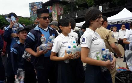 Estudiantes de varios colegios entregan en la feria botellas plásticas que reciclaron en sus planteles.