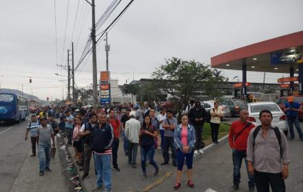 En la vía a Daule, a la altura de la entrada a Pascuales, decenas de personas esperan algún transporte particular que los lleven a sus lugares de trabajo.