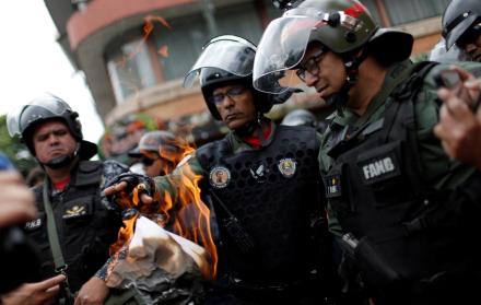 Imagen referencial. Un miembro de la guardia nacional quema un documento que fue entregado por un ciudadano cerca de la base militar de Caracas.