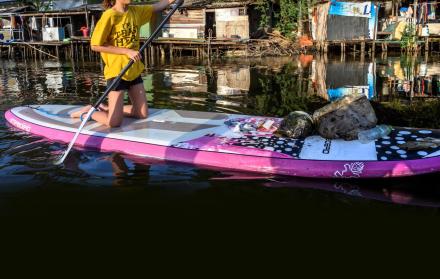 Contaminación. Ralyn Satidtanasarn, conocida como Lilly, rema para recoger desechos plásticos en un canal en Bangkok.