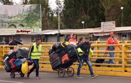 Un grupo de migrantes venezolanos caminan con sus pertenencias en el puente Rumichaca.  22 de agosto de 2018. 