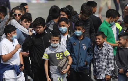 Varios niños se cubren con mascarillas debido a la alta concentración de partículas contaminantes en Ciudad de México.
