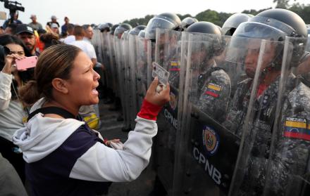 Ciudadanos venezolanos discuten con guardias de las Fuerzas de Venezuela sobre el Puente Simón Bolívar este sábado, en Cúcuta (Colombia). 