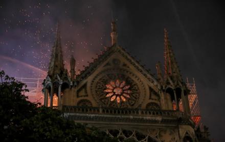 Las chispas llenan el aire mientras los miembros de la brigada de bomberos de París rocían agua para extinguir las llamas en la catedral de Notre Dame.