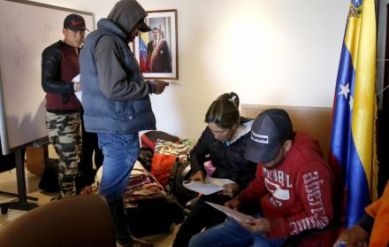 Ciudadanos venezolanos en Ecuador llenan formularios para abordar un vuelo con destino a Caracas.