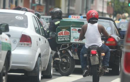 Peligro. Dos motociclistas intentan meterse en medio de los vehículos, sin tomar en cuenta la seguridad. 