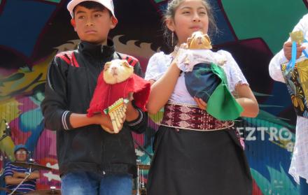 Dos niños con ‘Luisito’ y ‘Carmencita’, los cuyes que ganaron con su vestimenta. 