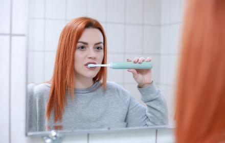 Mujer cepillándose los dientes.