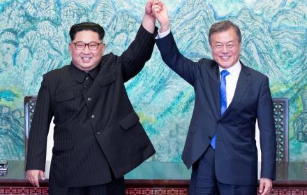 El líder norcoreano Kim Jong-un (i) y el presidente surcoreano, Moon Jae-in (d) se cogen de la mano tras la firma de un documento en el marco de la cumbre intercoreana en la zona de seguridad conjunta (JSA)
