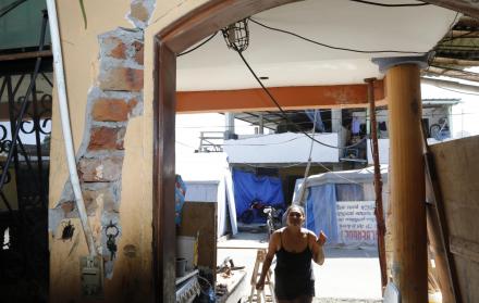 Manabí. Los rezagos del terremoto no han sido borrados. Una mujer ingresa a su casa, aún con daños varios.