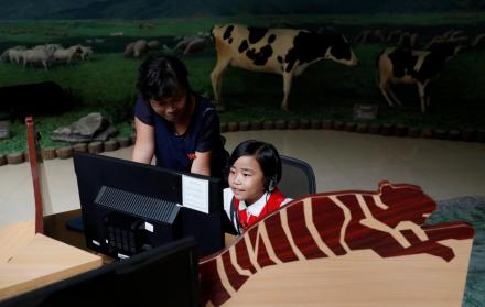 Aplicaciones. Una niña escucha información durante una visita al museo de Pionyang, en Corea del Norte.