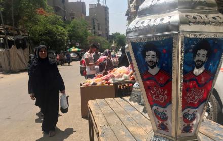 Una mujer observa un farol de colores, típico del mes sagrado de Ramadán, en el barrio islámico de El Cairo, que este año son diferentes ya que lucen el rostro del futbolista egipcio Mohamed Salah, que alumbra las calles y hogares del país. 