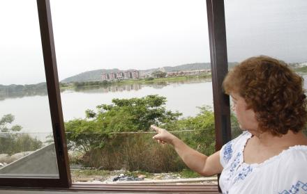 Noheli Rojas, residente de una urbanización de la zona, muestra la malla metálica que separa su vivienda del río y explica por qué se sienten expuestos.