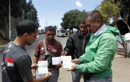 Los venezolanos Juan Hernández (d), Valerio de Jesús López, Carlos González y Luis Gamboa, quienes se encuentran en el intercambiador de Carcelén, al norte de Quito, aseguran que no hay plata para sacar el pasaporte o renovarlo. Ellos muestran sus pasapo