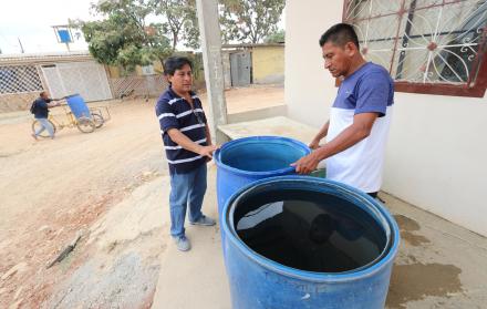 Alternativa. El usuario Nelson Quimí (derecha) recurre a los tanqueros para abastecerse de agua.