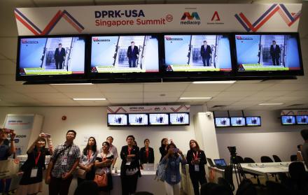 Expectativa. Un grupo de personas mira por pantallas de televisión la llegada del presidente estadounidense.