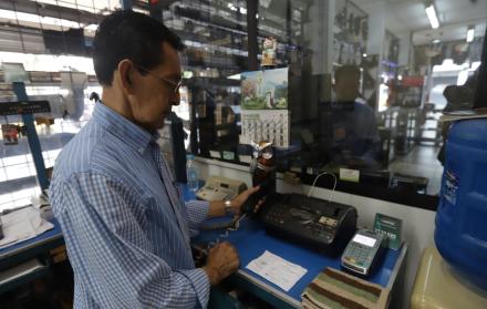 Negocios. Orlando Almeida muestra el teléfono fijo de su negocio y se lamenta de que no funcione la línea.