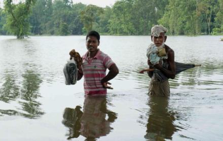 Personas caminan en el área sumergida por la inundación en Kurigram, Bangladesh 