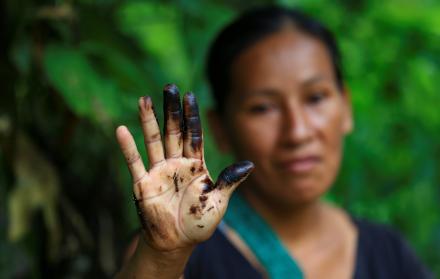 Una indígena de la comunidad de Amarumesa muestra en su mano residuos de petróleo en la Amazonía ecuatoriana.