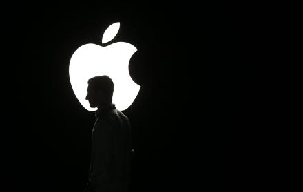 La silueta de un hombre se ve frente al logo de Apple, en una fotografía de archivo.