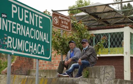 Dos conductores ecuatorianos esperan en el paso de Rumichaca a la devolución de su camión desde Colombia por un conductor de ese país antes de la reapertura de la frontera.