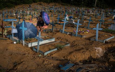Personas se protegen del sol mientras visitan las tumbas de familiares en el área destinada a las víctimas del Covid-19 en el cementerio Nossa Senhora Aparecida, en Manaos, en una fotografía de archivo.