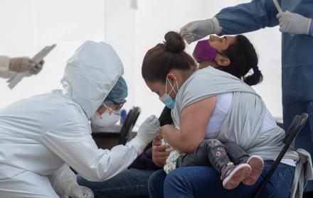 Una madre sostiene a su hija durante una prueba para detectar la covid-19 en el Hospital del IMSS 