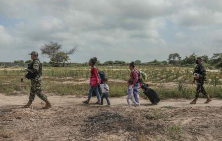 Miembros de la policía de Perú controlan el paso de migrantes venezolanos que intentan cruzar la frontera de Perú por la orilla del río Zarumilla, junto a Ecuador el 6 de mayo de 2022.