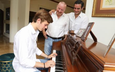 Guido Chiriboga High y dos de sus tres hijos en el piano de la casa.