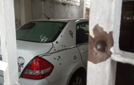 Las rejas de la puerta y la parte trasera de un vehículo quedaron con orificios de proyectiles.