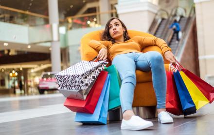 mujer con muchas compras sentada